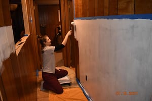 priming the hallway paneling before the wainscoting application